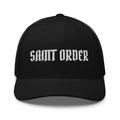 Front of the black Saint Order Signature Trucker cap, with a white embroidered Saint Order wordmark and curved visor.